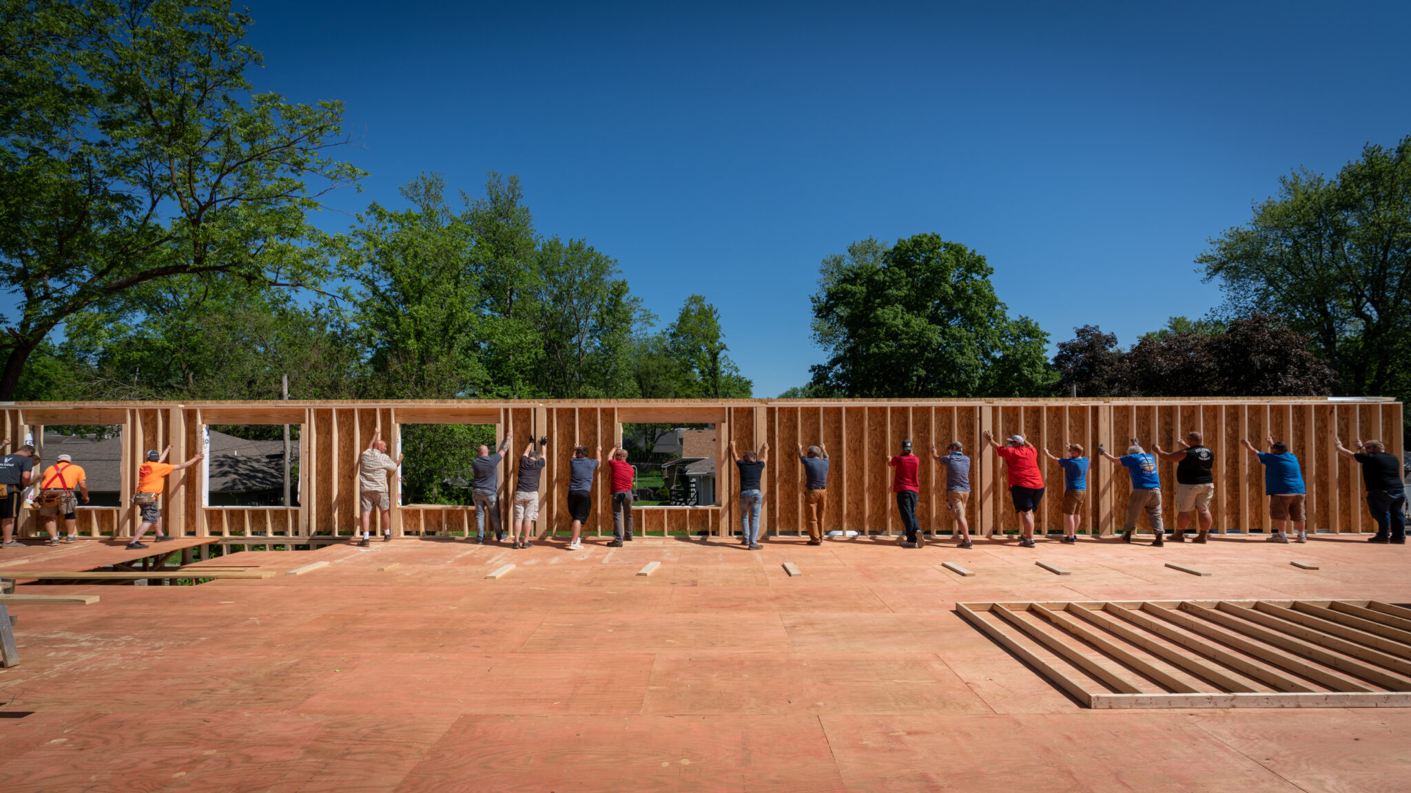A group of workers holding up a new wall